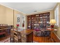 Comfortable living room with a full bookcase, hardwood floors, and a chair with footstool at 12018 Radbourne St, Winter Garden, FL 34787