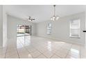 Open-concept living room with tile flooring, ceiling fan, and sliding glass doors to the pool area at 13254 Boulder Woods Cir, Orlando, FL 32824