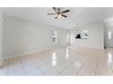 Bright living room featuring tile floors, large windows, and a view into the adjacent kitchen area at 13254 Boulder Woods Cir, Orlando, FL 32824