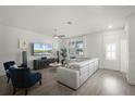 Bright, open living room features hardwood floors, modern furniture, and a large window at 13727 Bressler Aly, Windermere, FL 34786