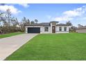 Charming single-story home featuring a well-manicured lawn and a two-car garage, perfect for suburban living at 16659 Sw 21St Avenue Rd, Ocala, FL 34473