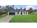 Charming single-story home featuring a well-manicured lawn and a two-car garage, perfect for suburban living at 16659 Sw 21St Avenue Rd, Ocala, FL 34473