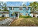 Inviting two-story home boasts fresh blue exterior, neat landscaping, and a charming covered entryway at 2504 Helen Ave, Orlando, FL 32804