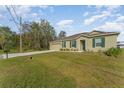 Suburban home with a large front lawn, a private mailbox, and an attached two car garage at 322 Dagama Ct, Kissimmee, FL 34758