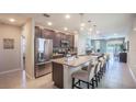 Modern kitchen featuring stainless steel appliances, granite countertops, and a spacious island with bar seating at 3856 Bluethread Way, Poinciana, FL 34759