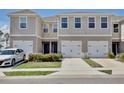 Townhome exterior with painted facade, white garage door, black hardware, and landscaped front yard at 421 Sedgewick Dr, Davenport, FL 33837