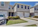 Charming townhomes with a white finish, garage, and landscaped front yard create a welcoming curb appeal at 421 Sedgewick Dr, Davenport, FL 33837