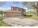 Beautiful two-story home with a three-car garage, complemented by a well-kept lawn and mature trees at 524 Quail View Ct, Debary, FL 32713