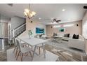 Open-concept living area with dining space, a modern ceiling fan, and a large TV at 524 Quail View Ct, Debary, FL 32713