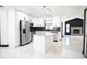 Modern kitchen with stainless steel appliances, black backsplash, an island, and polished marble floors at 5443 Aeolus Way, Orlando, FL 32808