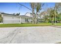 Expansive home exterior featuring a white picket fence, well manicured lawn, and comfortable front porch at 599 Glendevon Dr, New Smyrna Beach, FL 32168