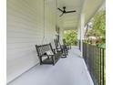 Inviting covered porch with ceiling fan and comfortable seating, perfect for relaxing outdoors at 599 Glendevon Dr, New Smyrna Beach, FL 32168
