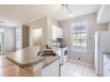 Efficient kitchen with a breakfast bar and white appliances, enhanced by natural light at 6340 Raleigh St # 1002, Orlando, FL 32835