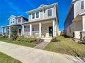 Attractive two-story home features a covered porch and a manicured lawn, creating a welcoming curb appeal at 6404 Pine Fork Aly, St Cloud, FL 34771