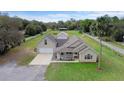 Stunning tan home featuring an attached garage, a charming porch, and lush, well-maintained landscaping at 735 Deerfoot Rd, Deland, FL 32720
