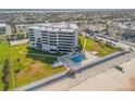 Aerial view of the building with a pool, lawn, and beach access at 901 S Atlantic Ave # 208, Ormond Beach, FL 32176