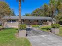 Inviting single-story home with a lush lawn, mature palm trees, and a long private driveway at 10031 Union Park Dr, Orlando, FL 32817