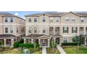 Two-story townhome features an exterior elevation, complemented by meticulously manicured landscaping and walkway at 10566 Green Ivy Ln, Orlando, FL 32832