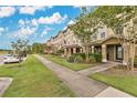 Beautiful street view of townhouses with well-kept lawns and sidewalks at 10566 Green Ivy Ln, Orlando, FL 32832