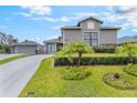 Well-maintained home with a lush lawn, accented by decorative palm trees and meticulous landscaping at 1094 Red Maple Way, New Smyrna Beach, FL 32168