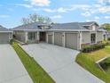 Charming exterior view of a well-kept home with an expansive driveway and three-car garage at 1094 Red Maple Way, New Smyrna Beach, FL 32168