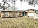 Charming single-story home with a well-maintained lawn, bright blue front door, and attached two car garage at 1197 Village Forest Pl, Winter Park, FL 32792