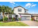 Beautiful two-story home with a well-manicured lawn, brick driveway, and a welcoming facade with an American flag at 1298 Patterson Ter, Lake Mary, FL 32746