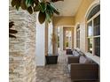 Covered outdoor patio features stone columns, neutral furniture, and a stone paver floor at 13106 Alderley Dr, Orlando, FL 32832