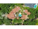 Aerial view of the luxurious home features a tile roof, mature landscaping, and a stunning backyard pool and spa at 1400 Alabama Dr, Winter Park, FL 32789