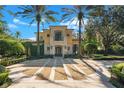 Stunning Mediterranean home featuring a circular driveway and meticulously landscaped grounds with mature palm trees at 1400 Alabama Dr, Winter Park, FL 32789