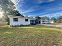 Well-maintained single-story home with a lush front lawn and a covered carport at 1416 Bennett Rd, Orlando, FL 32803