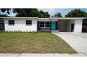 Inviting single-story home with a well-manicured lawn, neutral exterior, and an attached carport at 1416 Bennett Rd, Orlando, FL 32803