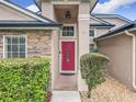 Close-up of front door, showcasing stone accents and manicured landscaping at 1609 River Birch Ave, Oviedo, FL 32765