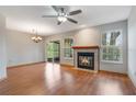 Spacious living room featuring a fireplace, ceiling fan, and sliding glass doors at 2201 Coach House Blvd # 3, Orlando, FL 32812