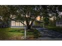 Dusk view of a charming single-story home featuring a well-maintained front yard, shade tree, and covered carport at 2706 Cranmoor Dr, Kissimmee, FL 34758