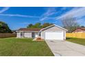 Attractive single-story home featuring a well-kept lawn, gray exterior, and attached two car garage at 2740 Courtland Blvd, Deltona, FL 32738