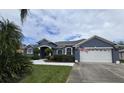 Inviting single-story home featuring a well-maintained lawn and an attached two-car garage, flying an American Flag at 3172 Bayview Ln, St Cloud, FL 34772