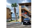 Exterior view of condo building showing stairway and accessible parking at 415 N Halifax Ave # 216, Daytona Beach, FL 32118