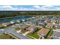 Aerial view of a two-story home with a lake view surrounded by a well manicured neighborhood at 5607 Western Sky Pl, St Cloud, FL 34771