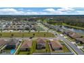 Aerial view of the property showing the house, backyard, and neighborhood with nearby green spaces and pond at 5607 Western Sky Pl, St Cloud, FL 34771