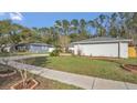 Lush front yard features manicured greenery and a brick-edged flowerbed, adding charm to the home's exterior at 8691 Contoura Dr, Orlando, FL 32810