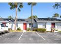 Condo exterior view with palm trees, street parking and brightly colored doors at 97 Lake Villa Way, Kissimmee, FL 34743