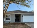Charming single-story home with a two-car garage, freshly painted, and well-maintained landscaping at 117 Stewart Lake Loop, Groveland, FL 34736