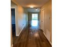 Inviting hallway with wood-look floors, leading to a bright and airy living space with sliding glass doors at 117 Stewart Lake Loop, Groveland, FL 34736