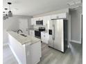 Well-lit kitchen featuring stainless steel appliances, white cabinets and a granite countertop at 1200 Jarecki Ave, Holly Hill, FL 32117