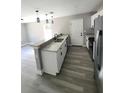 Bright kitchen featuring granite countertops, stainless steel appliances and laminate floors at 1200 Jarecki Ave, Holly Hill, FL 32117