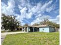 Inviting single-story home with a unique covered entryway and lush front lawn under a bright, partly cloudy sky at 1207 Rich Moor Cir, Orlando, FL 32807