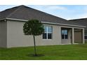 Backyard with a green lawn, small tree, and covered lanai with support columns at 12126 Homestead Park Ln, Orlando, FL 32824