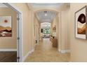 Inviting hallway leads to an open living area with tile flooring and decorative art pieces at 1392 Zeek Ridge St, Clermont, FL 34715
