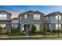 Charming two-story home with a manicured lawn and inviting front porch at dusk at 14146 Lanikai Beach Dr, Orlando, FL 32827